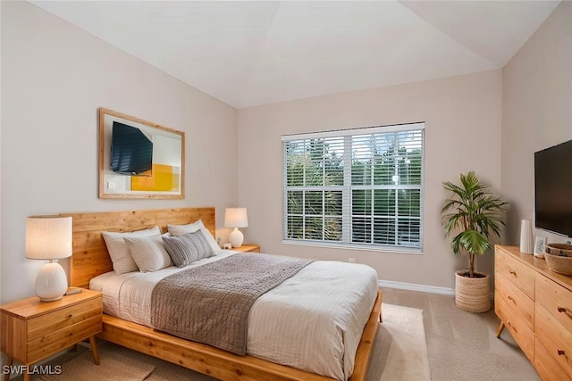 bedroom featuring light colored carpet and baseboards