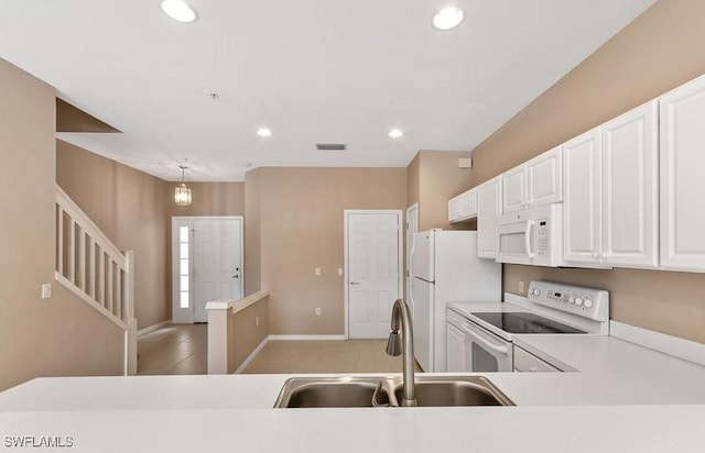 1172 Oxford Ln Unit 27, Naples, FL 34105 - kitchen featuring white appliances, light countertops, white cabinetry, a sink, and recessed lighting