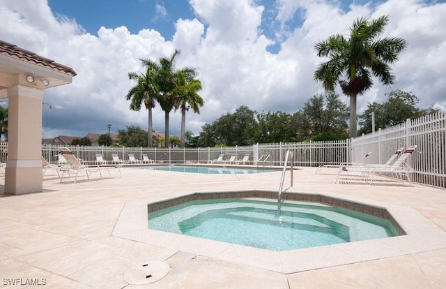 1172 Oxford Ln Unit 27, Naples, FL 34105 - community pool featuring a community hot tub, a patio area, and fence
