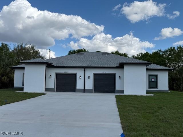 view of front of property with a garage and a front lawn