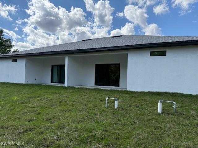 rear view of house featuring a lawn