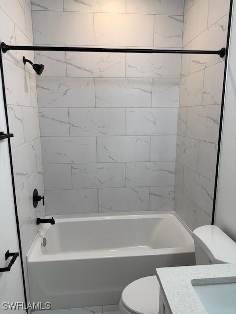 full bathroom with tiled shower / bath, vanity, and toilet