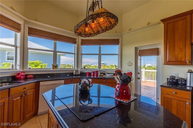 621 Rum Rd, Captiva, FL 33924 - kitchen with white dishwasher, brown cabinetry, dark stone counters, and light tile patterned floors