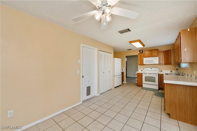 4001 E Sunflower Cir, Labelle, FL 33935 - kitchen featuring light countertops, white appliances, brown cabinets, a sink, and light tile patterned floors