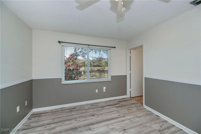 4001 E Sunflower Cir, Labelle, FL 33935 - spare room featuring a textured ceiling, visible vents, baseboards, wood finished floors, and a ceiling fan