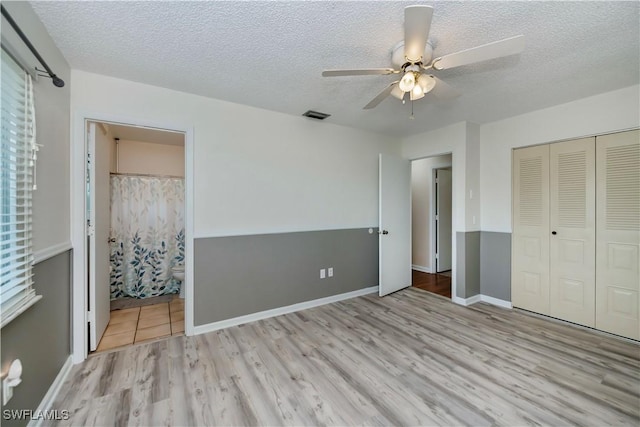 4001 E Sunflower Cir, Labelle, FL 33935 - unfurnished bedroom with a textured ceiling, ensuite bath, visible vents, a closet, and wood finished floors