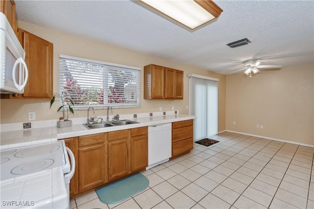 4001 E Sunflower Cir, Labelle, FL 33935 - kitchen with tile counters, white appliances, a sink, visible vents, and a ceiling fan