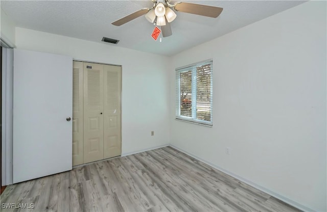 4001 E Sunflower Cir, Labelle, FL 33935 - unfurnished bedroom with a closet, a textured ceiling, visible vents, wood finished floors, and a ceiling fan