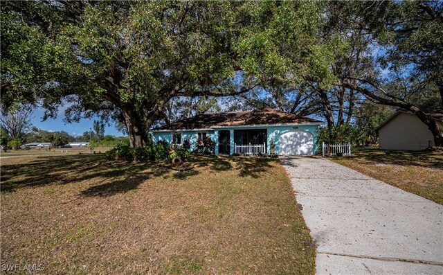 4001 E Sunflower Cir, Labelle, FL 33935 - view of front of home featuring driveway, an attached garage, and a front yard