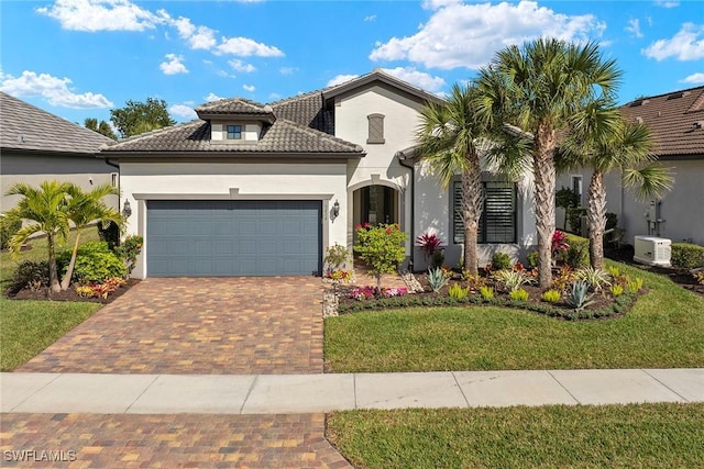 mediterranean / spanish house featuring a garage and a front lawn