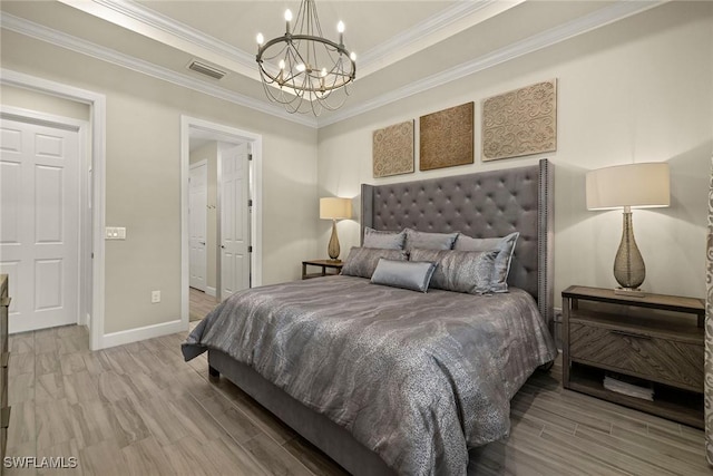 bedroom with hardwood / wood-style flooring, crown molding, a raised ceiling, and a notable chandelier