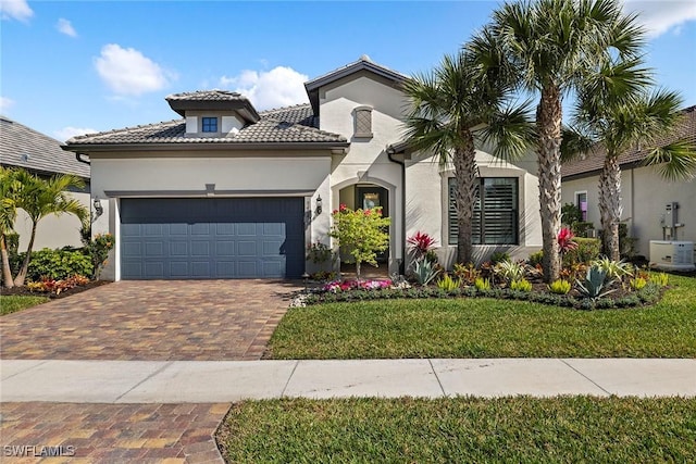 mediterranean / spanish-style home featuring a garage and a front yard