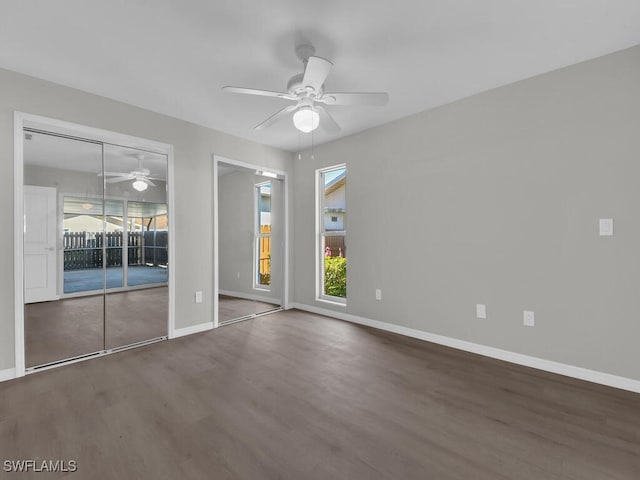 spare room with ceiling fan, wood finished floors, and baseboards