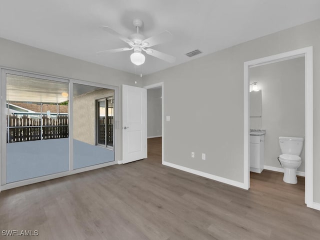 unfurnished bedroom featuring access to outside, visible vents, baseboards, and wood finished floors