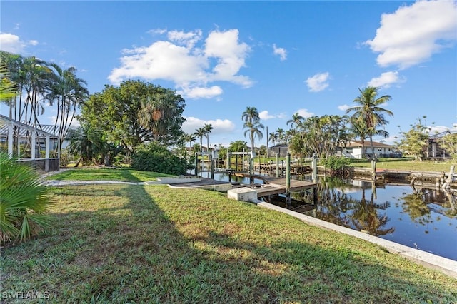 view of dock with a yard and a water view