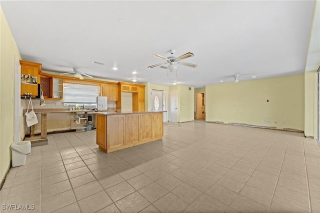 kitchen with ceiling fan, a kitchen island, and light tile patterned floors