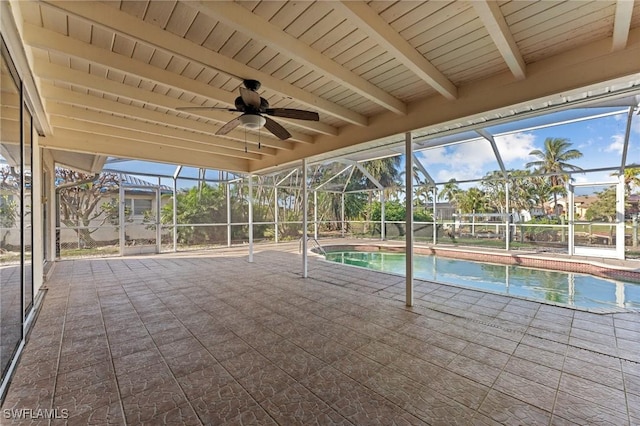 view of pool with a patio area, ceiling fan, and glass enclosure