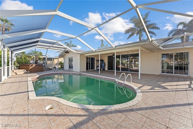 view of pool with a hot tub, a patio, and a lanai