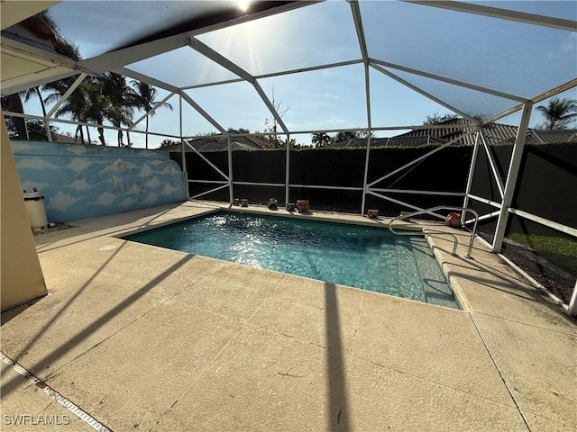 view of swimming pool featuring a patio, glass enclosure, and a fenced in pool