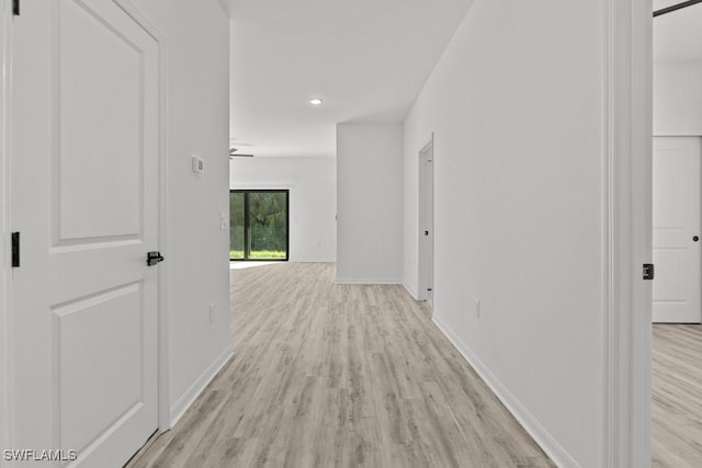 hallway featuring light wood-style floors and baseboards