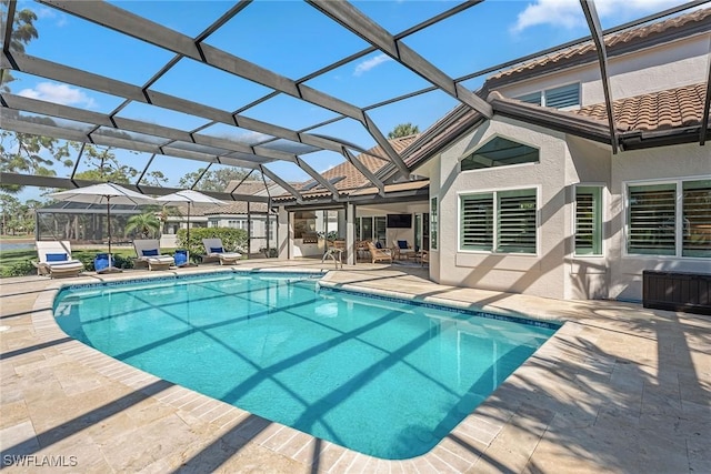 view of swimming pool with glass enclosure and a patio area