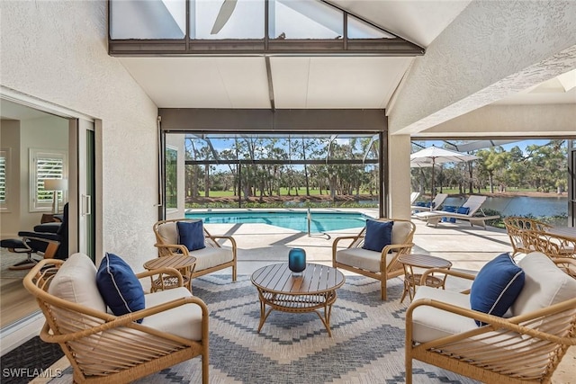 sunroom with lofted ceiling and a pool