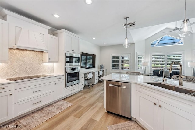 kitchen with sink, appliances with stainless steel finishes, hanging light fixtures, light hardwood / wood-style floors, and white cabinets