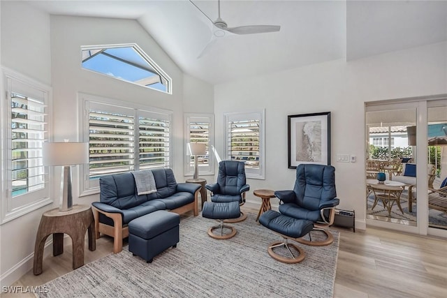 living room with ceiling fan, high vaulted ceiling, and light hardwood / wood-style flooring