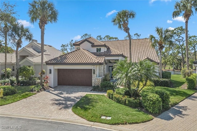 mediterranean / spanish home featuring a garage and a front yard