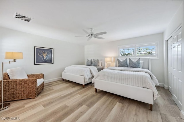 bedroom with ceiling fan, a closet, and light hardwood / wood-style flooring