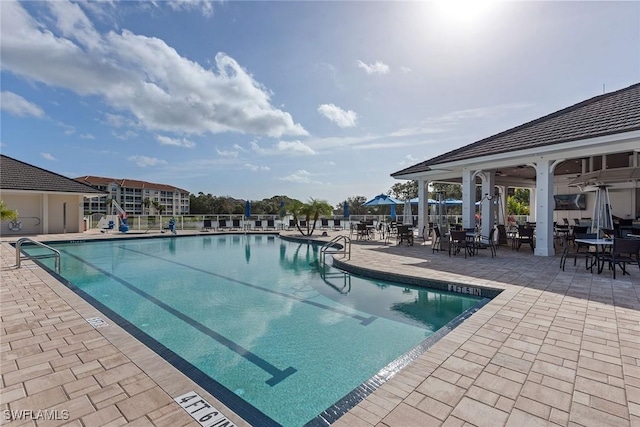 view of swimming pool with a patio and ceiling fan