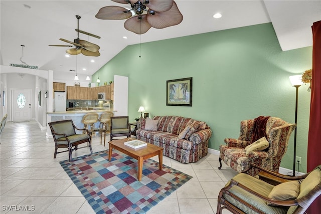 tiled living room with ceiling fan and high vaulted ceiling