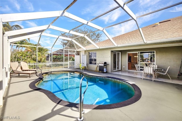 view of swimming pool featuring a lanai, a patio area, and grilling area