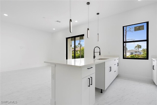 3173 Sunshine Blvd NW, Lehigh Acres, FL 33971 - kitchen with sink, a wealth of natural light, hanging light fixtures, and white cabinets