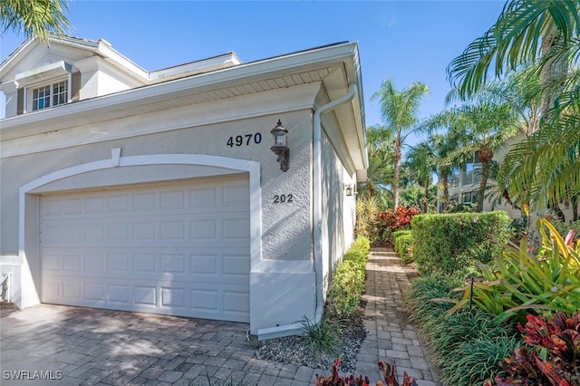 garage with decorative driveway