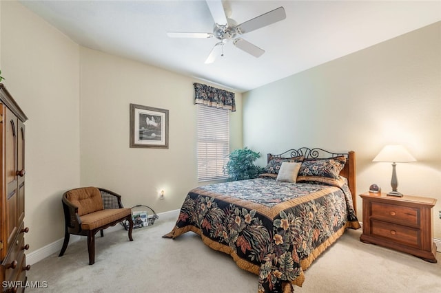 bedroom with a ceiling fan, light carpet, and baseboards