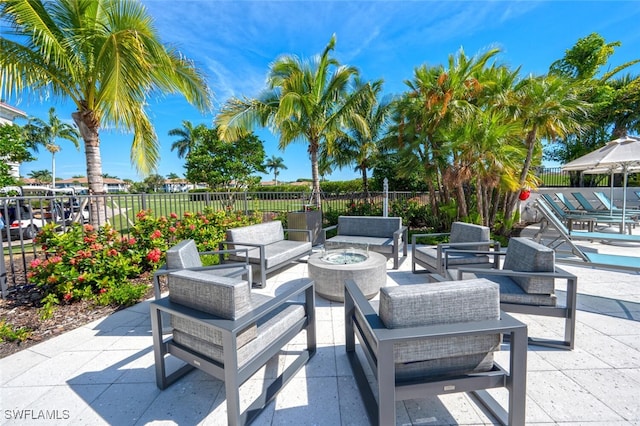 view of patio / terrace with fence and an outdoor living space with a fire pit