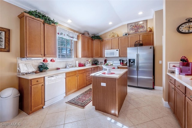 kitchen featuring a center island, light countertops, decorative backsplash, vaulted ceiling, and white appliances