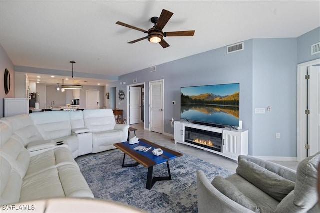 tiled living room featuring sink and ceiling fan