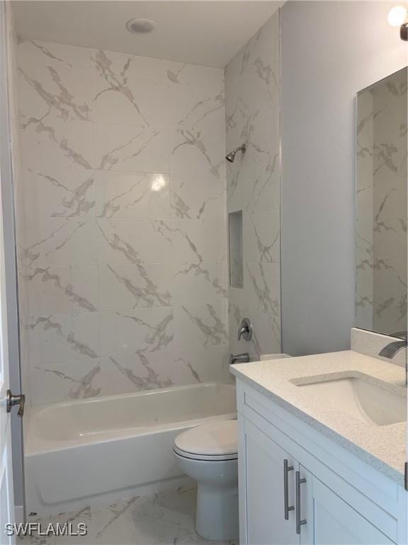 full bathroom featuring tiled shower / bath, vanity, and toilet