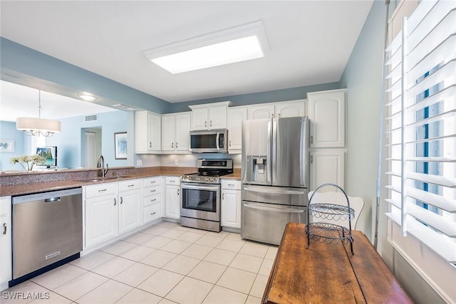 kitchen featuring white cabinetry, sink, decorative light fixtures, and stainless steel appliances