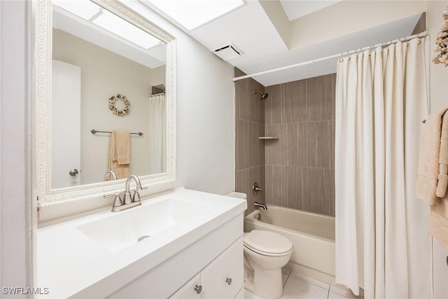 full bathroom with shower / tub combo with curtain, tile patterned flooring, a skylight, vanity, and toilet