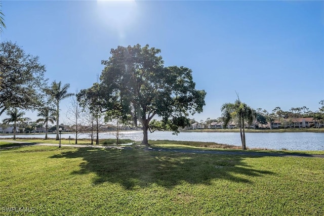 view of property's community featuring a lawn and a water view