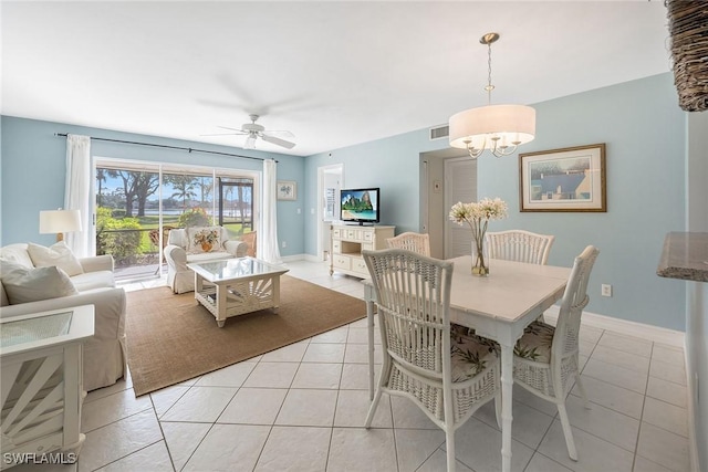 tiled dining area featuring ceiling fan with notable chandelier