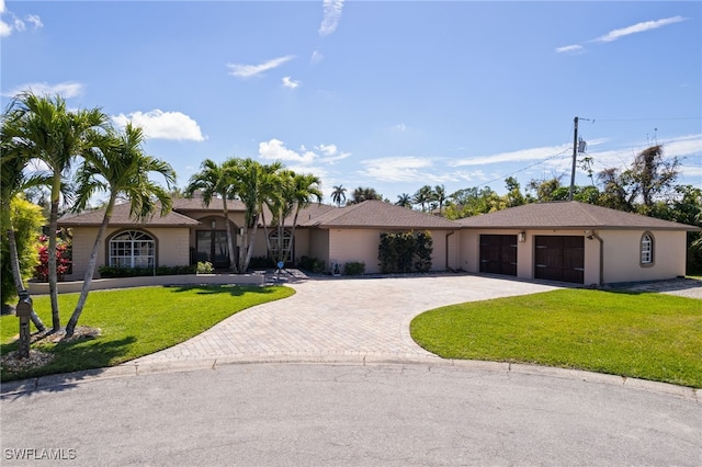 ranch-style house with decorative driveway, a front yard, and stucco siding