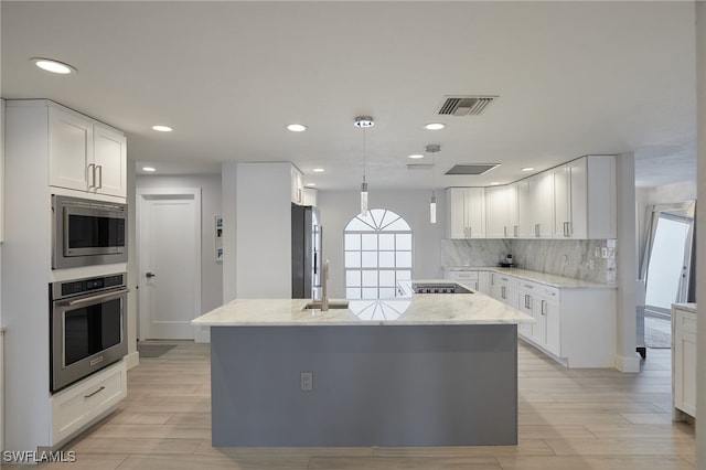 kitchen with visible vents, white cabinets, decorative backsplash, light stone countertops, and stainless steel appliances