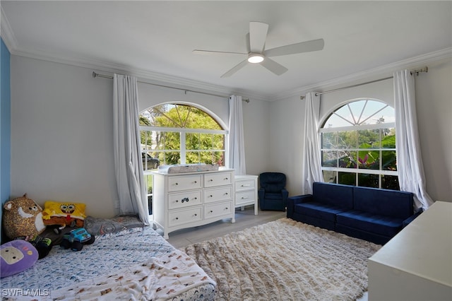 bedroom featuring ornamental molding, multiple windows, and ceiling fan