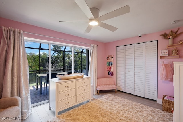 bedroom featuring access to outside, a closet, light wood-style flooring, and a ceiling fan