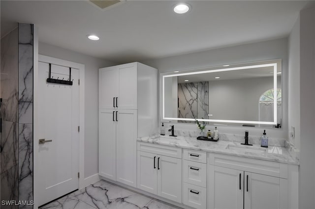 bathroom with recessed lighting, marble finish floor, a sink, and double vanity