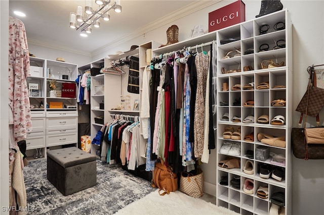 walk in closet with a chandelier